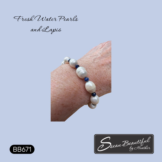 A close-up of a person's wrist wearing a beaded bracelet made of large white freshwater pearls and small dark blue beads, on a light blue background with the text 'Fresh Water Pearls and Lapis' and the brand name 'Sseau Beautiful by Heather'