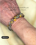 Bracelet with yellow and grey luminescent beads on a wrist, labeled 'Goddess Style Adjustable Bracelet with Golden Aura Quartz'.
