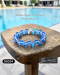 Blue bracelet on a wooden stool with pool in the background