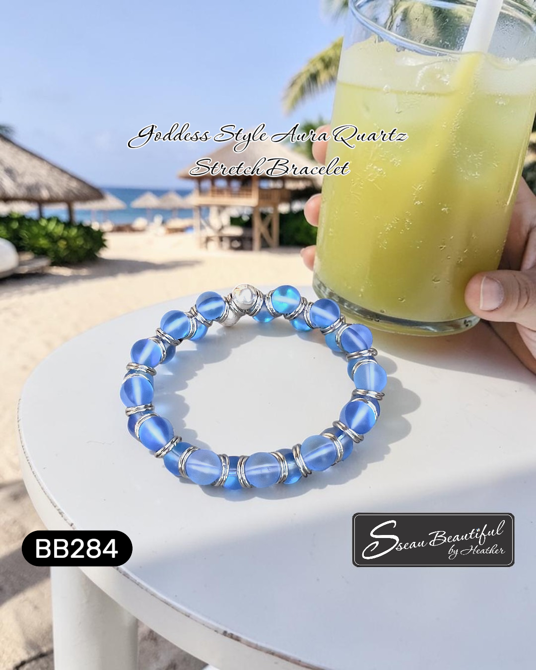 Blue beaded bracelet on a table with a beach setting and a drink in the background