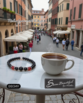 Cup of coffee and bracelet on a table with a blurred street scene in the background