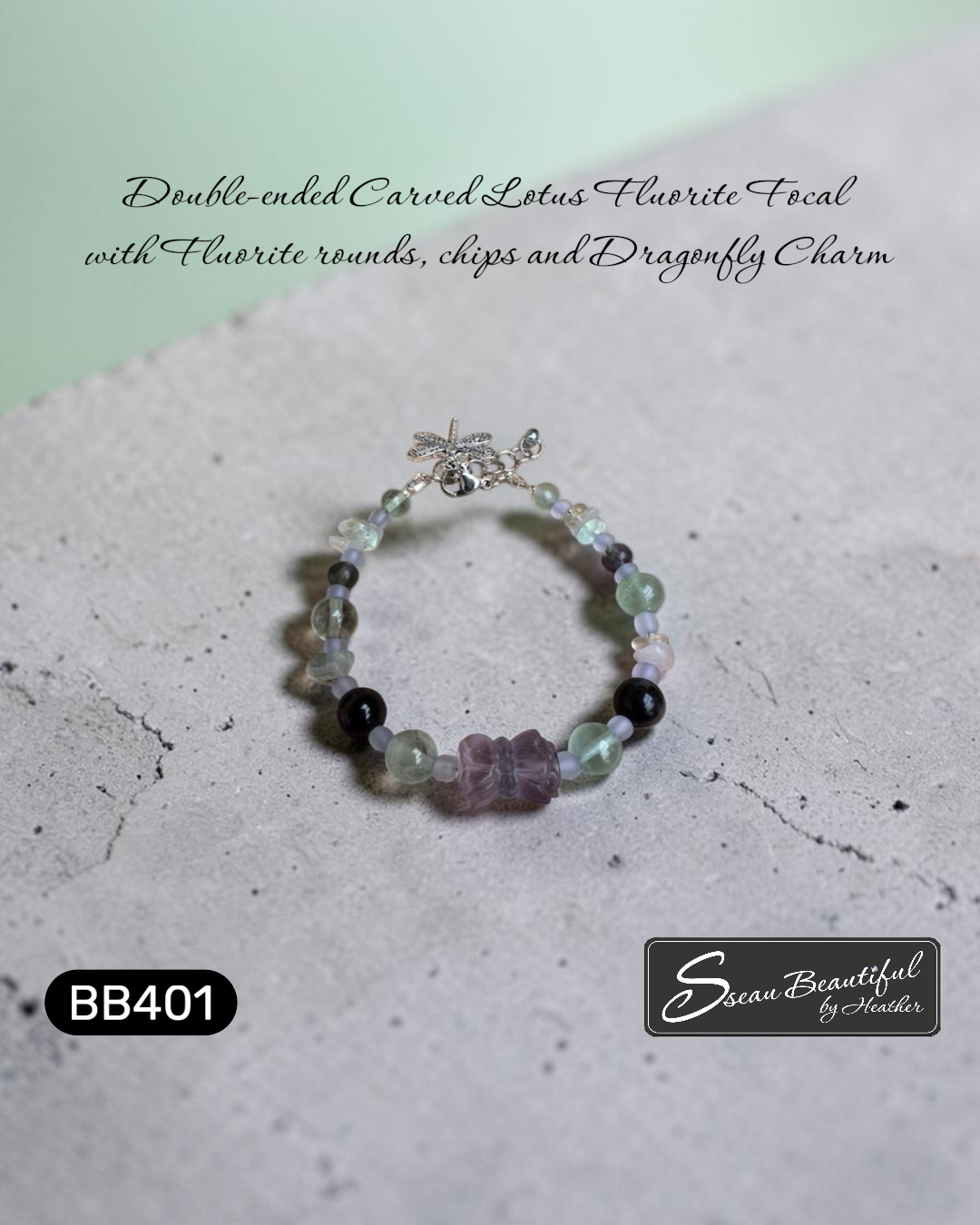 Photo of an adjustable bracelet strung with Fluorite round and chip beads featuring a double-ended carved Lotus Fluorite focal with a lobster clasp, extender, and a dragonfly charm, on a textured surface with descriptive  text, "Sseau Beautiful" logo and model number