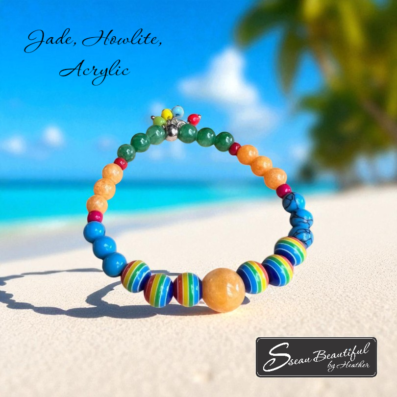 Colorful beaded bracelet on a sandy beach with ocean view