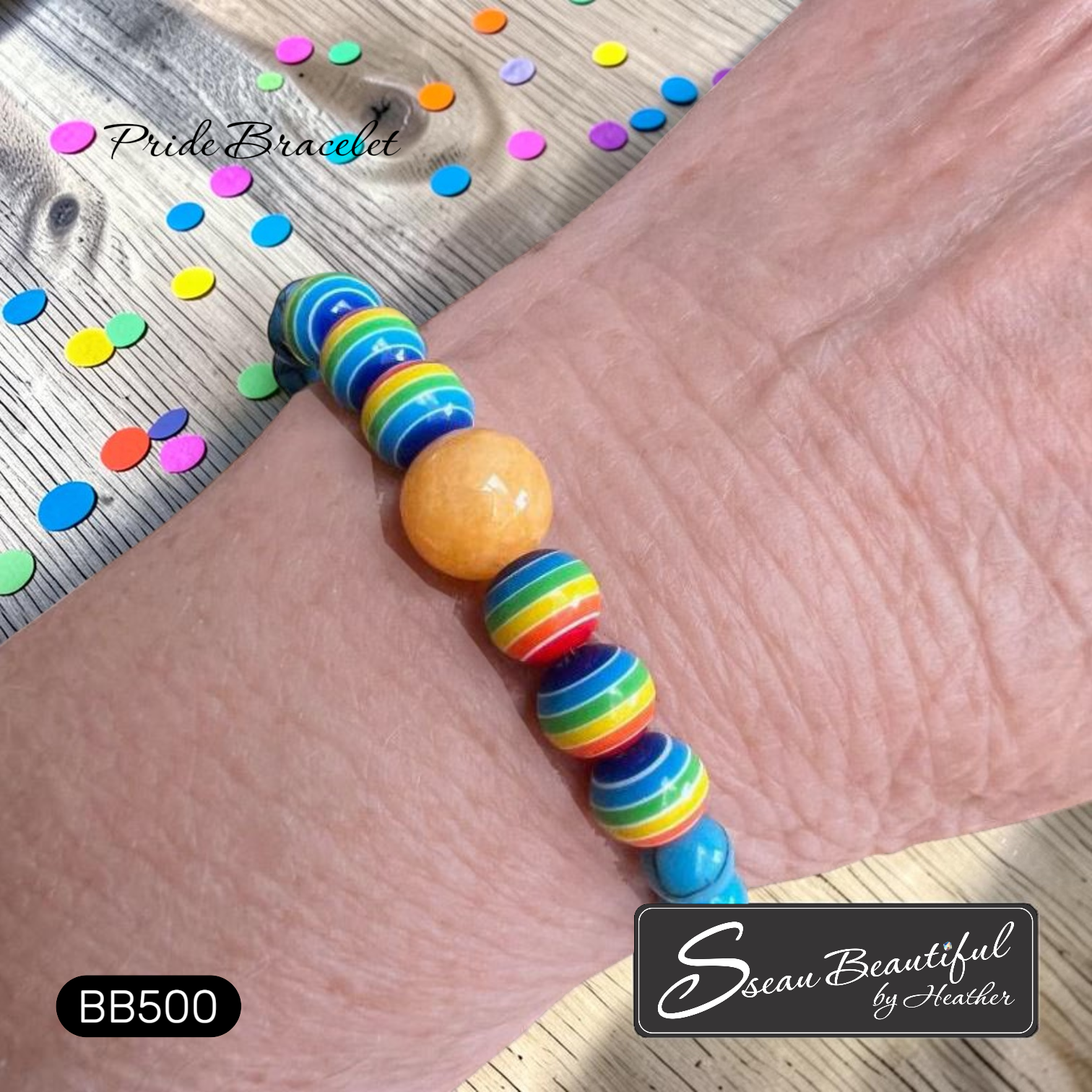 Colorful Pride Rainbow striped bracelet on a wrist with 'Sseau Beautiful' branding.