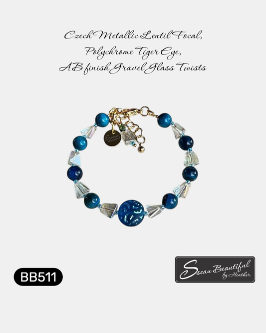 Adjustable 6.69 inch bracelet with a Czech Glass focal, Blue Tiger Eye rounds, AB finished Glass Nuggets, matching dangle, and a Stainless Steel Lobster Clasp and Extender 