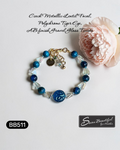 Adjustable 6.69 inch bracelet with a Czech Glass focal, Blue Tiger Eye rounds, AB finished Glass Nuggets, matching dangle, and a Stainless Steel Lobster Clasp and Extender 