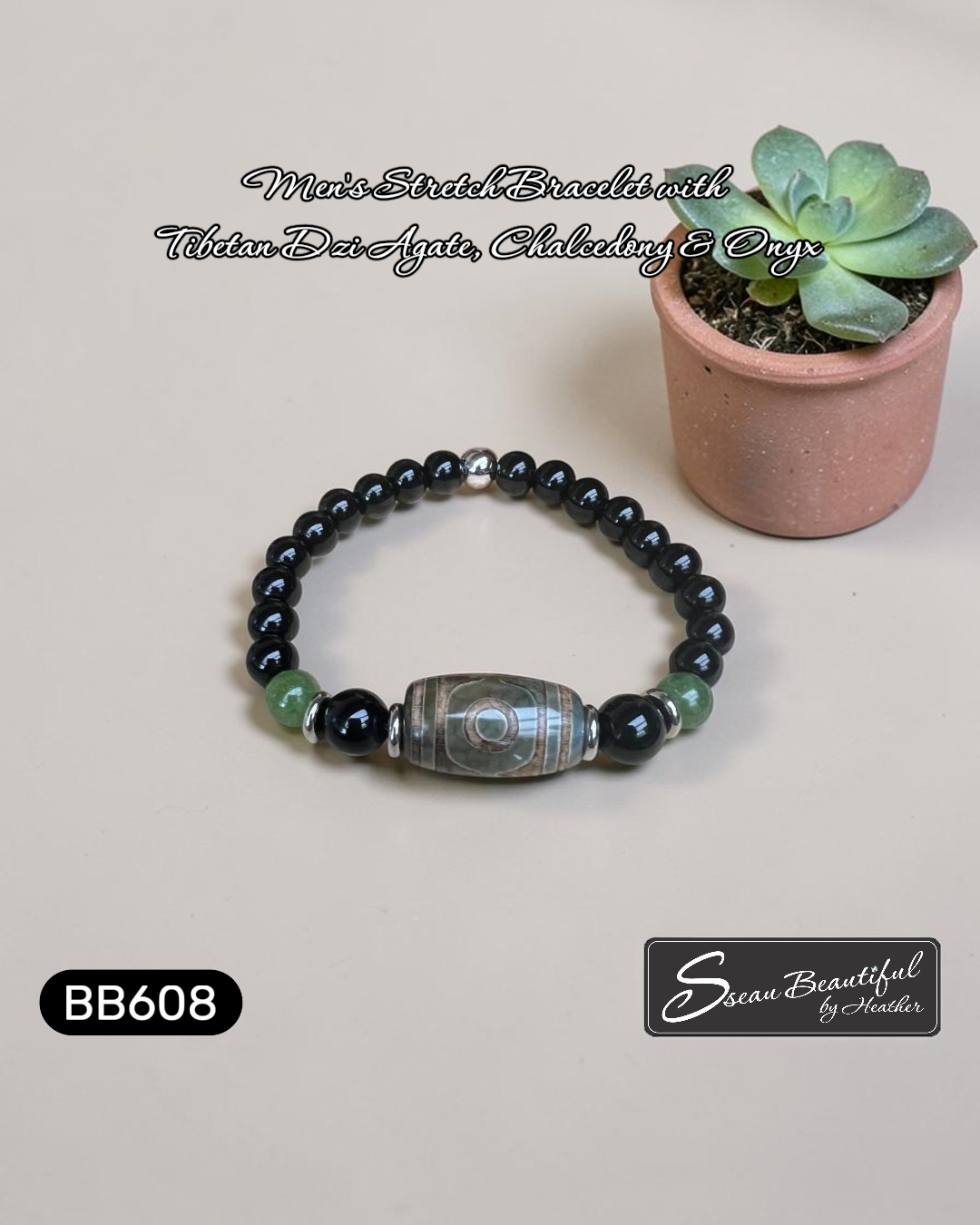 Black beaded bracelet with a central stone on a light surface next to a small potted plant, with branding visible.