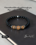 Black beaded bracelet with silver accents on a dark surface, featuring text about materials and brand.