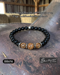 Black beaded bracelet with silver accents on a rustic surface, featuring 'Sseau Beautiful' branding.