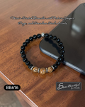 Black beaded bracelet with silver accents on a wooden surface next to a smartphone, with 'Sseau Beautiful' branding.