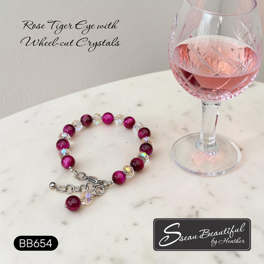 Rose Tiger Eye bracelet with wheel-cut crystals next to a glass of pink wine on a marble surface, with 'Sseau Beautiful by Heather' branding.