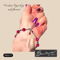 A close-up of a hand wearing a beaded bracelet with fuchsia tiger-eye and garnet beads, silver-toned stainless steel chain links, and small dangling charms. The background is a solid beige color, with text reading 'Fuchsia Tiger Eye and Garnet' and a logo for 'Sseau Beautiful by Heather'.
