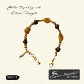 A beaded bracelet with golden tiger eye and citrine nuggets and gold-toned stainless steel beads, displayed on a cream background with brand text 'Sseau Beautiful by Heather' and style code 'BB673'.