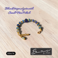 A beaded bracelet made of blue and light blue agate beads with gold spacer beads and a gold-tone Stainless Steel clasp, displayed on a light wood surface. Text overlays read 'Blue Stripe Agate with Czech Fire Polish' and 'BB674', with a logo for 'Sseau Beautiful by Heather' at the bottom right