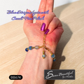 The back of a bracelet with blue beads and gold accents, shown worn on a person's wrist. The image features purple text overlay reading 'Blue Stripe Agate with Czech Fire Polish' and a black brand label at the bottom right reading 'Sseau Beautiful by Heather'.