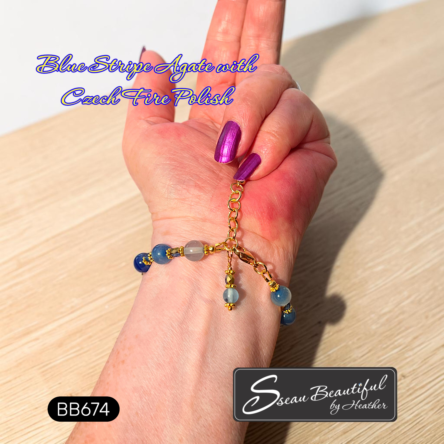 The back of a bracelet with blue beads and gold accents, shown worn on a person's wrist. The image features purple text overlay reading 'Blue Stripe Agate with Czech Fire Polish' and a black brand label at the bottom right reading 'Sseau Beautiful by Heather'.