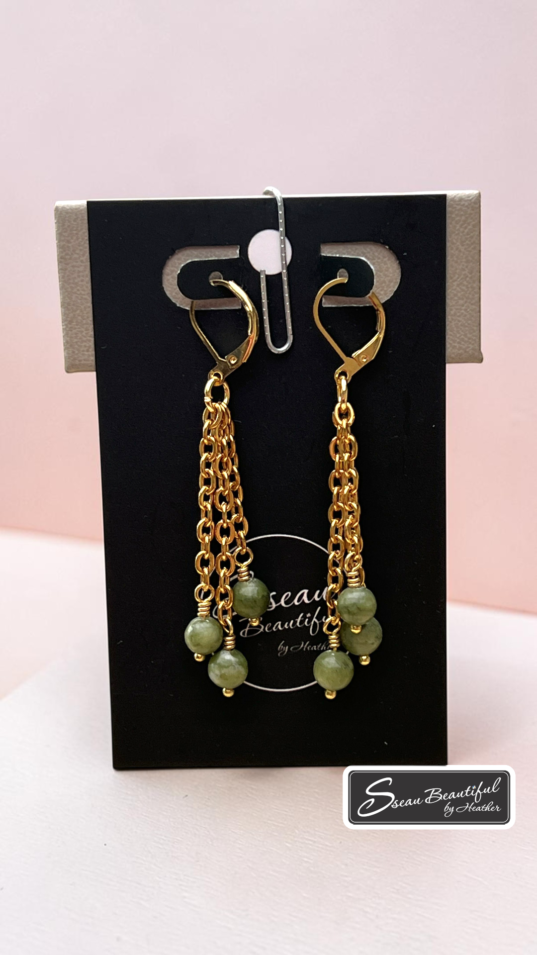 Jade and chain earrings hanging on maker's card, Sseau Beautiful logo in lower right corner