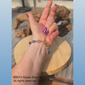 video showing a bracelet worn on a woman's slowing turning arm, then changing to a shot of the same bracelet shown on a rotating stand.