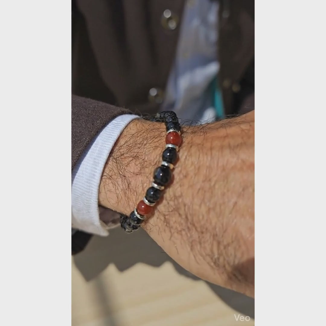 man wearing a Red Agate and Black Onyx bracelet, Bracelet on plain marble surface, Sseau Beautiful by Heather logo.