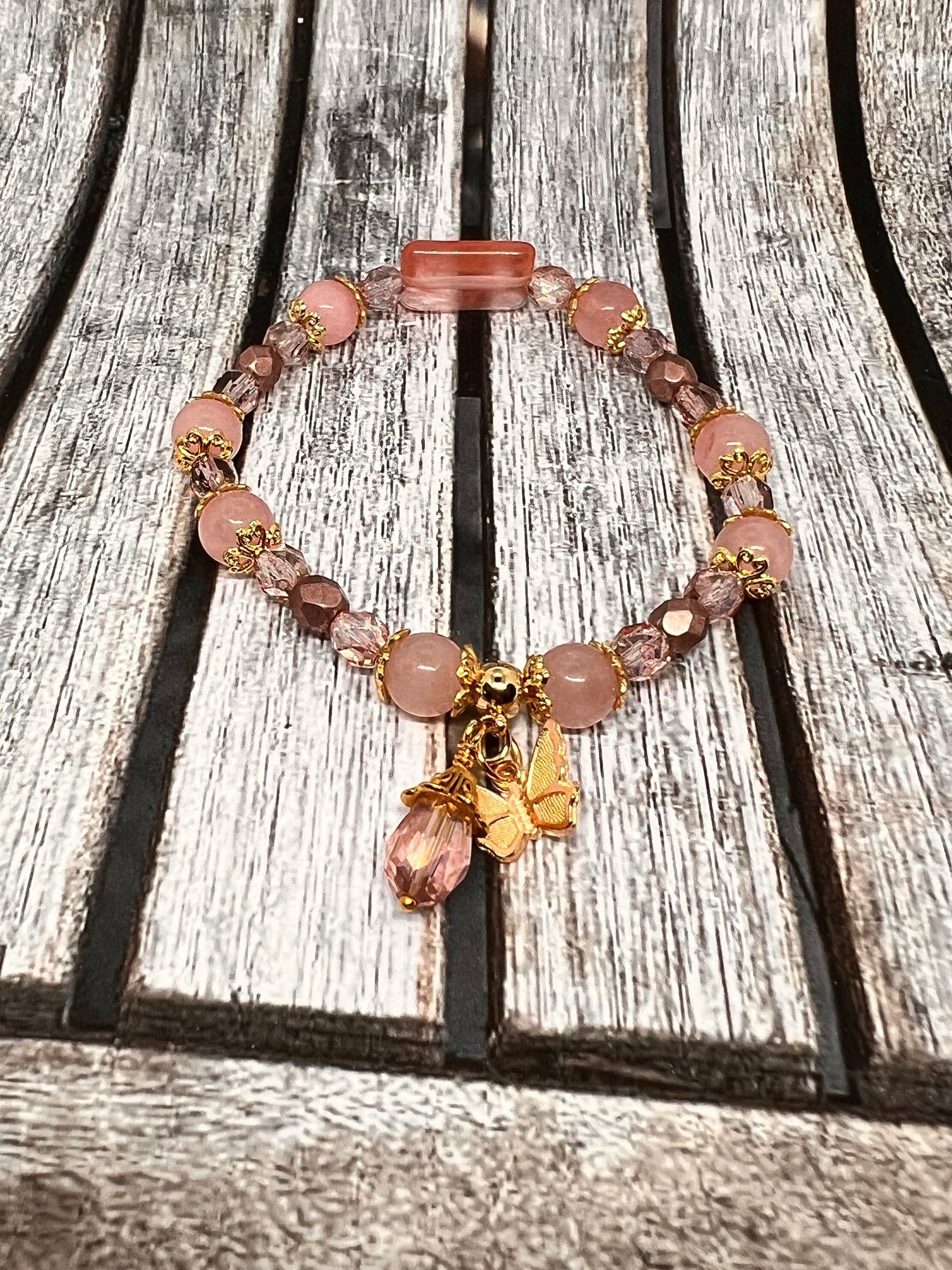 Sseau Beautiful! Strawberry Dream stretch bracelet with rose quartz, strawberry quartz, Czech crystals, gold bead caps, butterfly charm, and pink teardrop dangle.