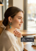 Sseau Beautiful! turquoise heart and floral dangle earrings with hypoallergenic stainless steel lever backs shown on a model
