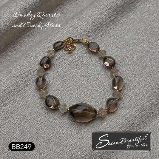 Sseau Beautiful! adjustable bracelet with large oval smokey quartz focal stone, smokey quartz nuggets, and Czech glass spacers. Gold-tone clasp.
